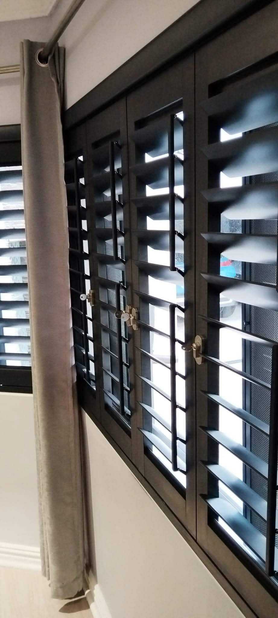 White aluminium security shutters installed on a home window.